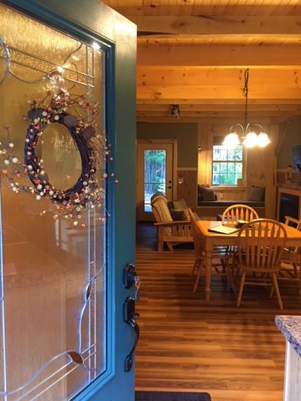 Entering one of the cabins with wood floors and dining table and chairs