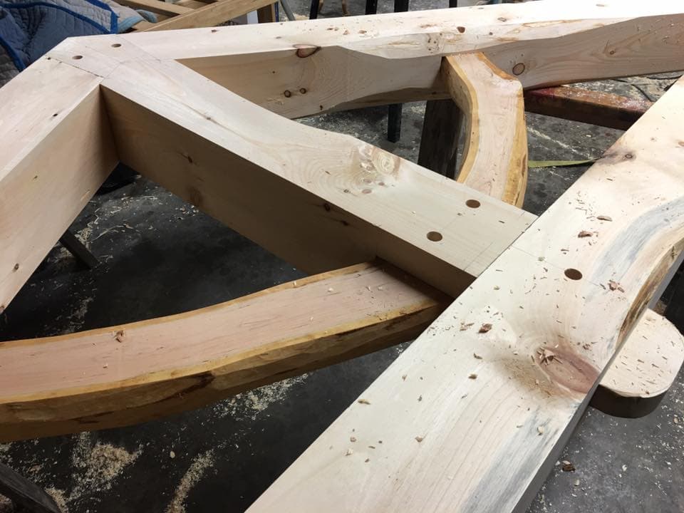 Close-up of unfinished wooden beams arranged in a frame.
