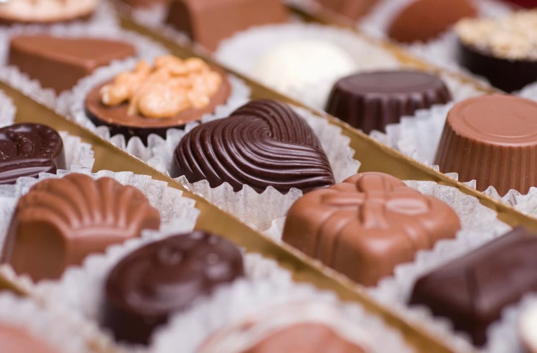 An assortment of various chocolate confections arranged in a box.