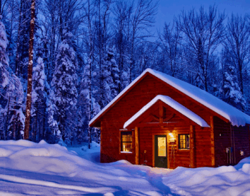Inviting timber frame cabin in snow at dusk