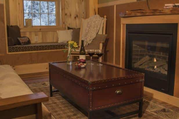 Evening Star sitting area, window with built-in seat, fireplace, wood furniture with cushions and trunk styled coffee table