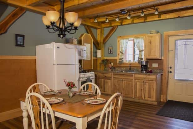 Serene Outlook kitchen, wood floor, ceiling and cabinets, glass door, window over sink, dinette table for four