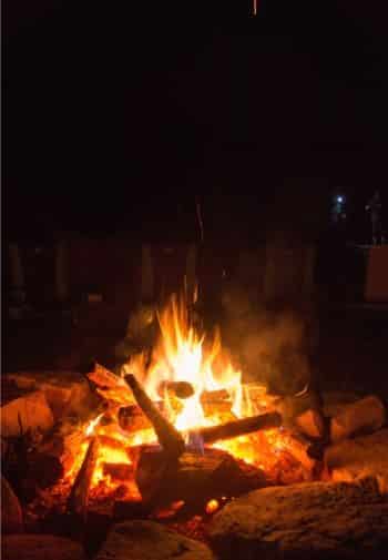 Hot glowing campfire outside amidst a dark night sky